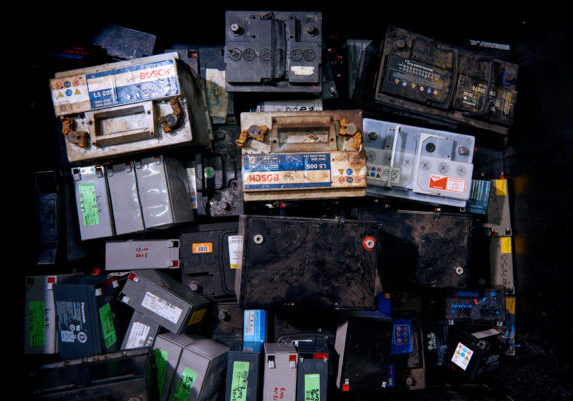 Een volle verzamelbak met menig oude accu die klaarstaat voor milieuvriendelijke recycling bij Schenk Recycling.