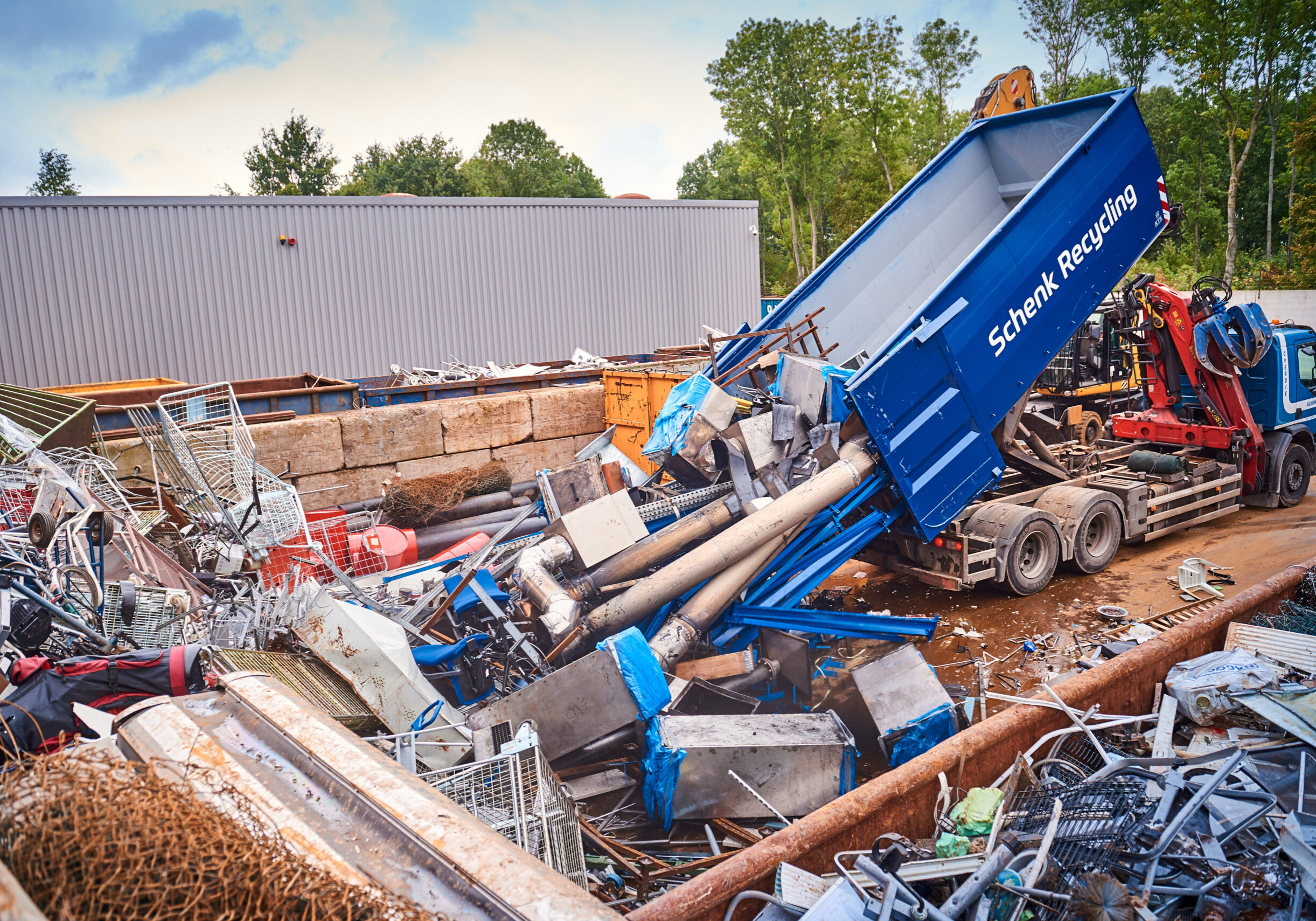 Oud ijzer wordt gestort uit een 40 kuub container van Schenk Recycling