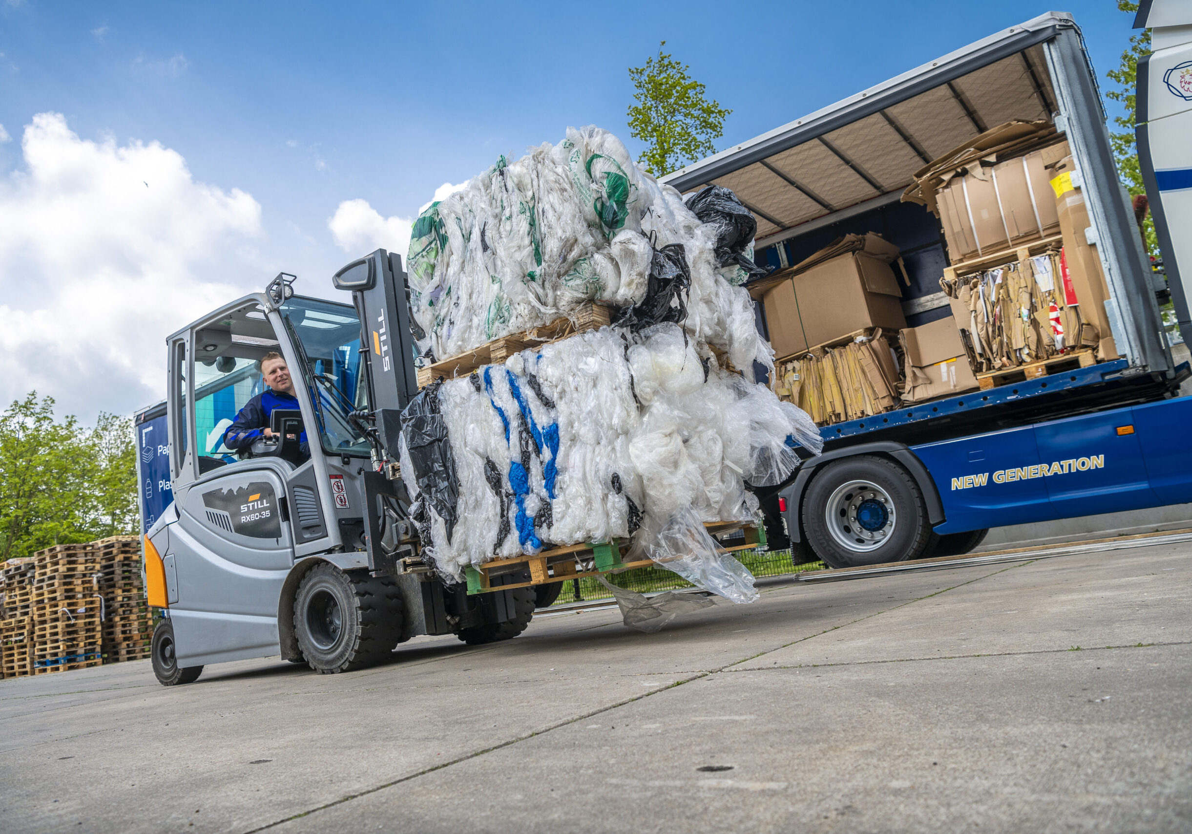 Heftruck van Schenk Recycling met twee balen folie op weg naar kunststofverwerking