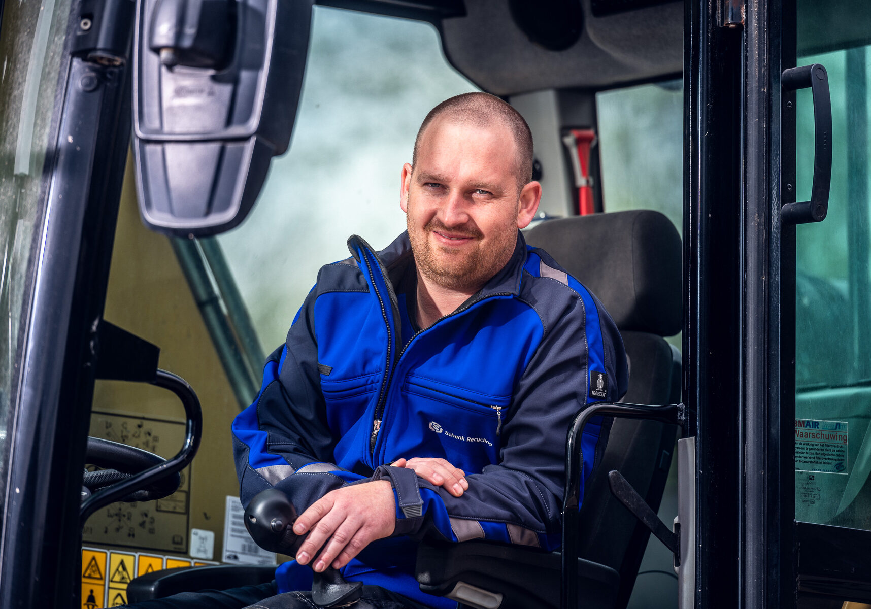 Medewerker van Schenk Recycling in een machine, dé metaalhandel voor klanten uit Lelystad.