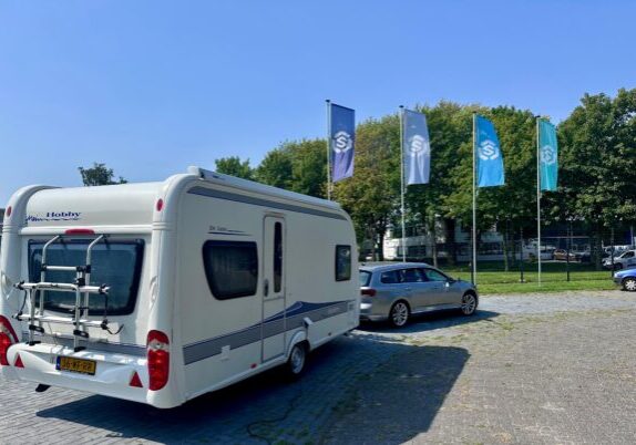 Een auto met caravan op het terrein van Schenk Recycling bij de Weegbrug Almere
